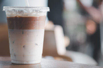 Cold iced latte coffee, the bottom as milk top by coffee shot in a plastic glass 16oz.