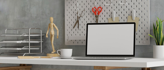 Laptop with mock-up screen in loft working space with tools and supplies, 3D rendering