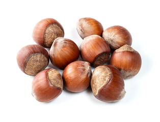 several unshelled hazelnuts closeup on white