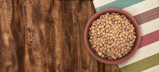 Walnut wood textureLentils in a Ceramic Bowl. These nutritious legumes are high in protein and fiber. The image is a cut out, isolated on a white background, with a clipping path.