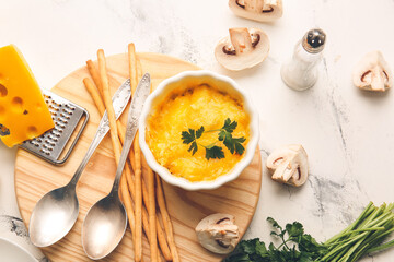 Ramekin with tasty julienne and ingredients on light background