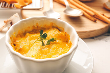 Ramekin with tasty julienne on light background, closeup