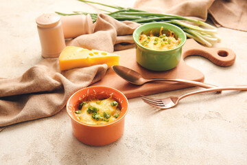 Ramekins with tasty julienne and ingredients on light background