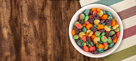 Top view of bowl with fruit cereal naturally and artificially fruit flavored sweetened corn puffs. Cereal fruity shapes - obrazy, fototapety, plakaty