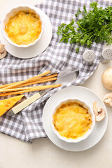 Ramekins with tasty julienne and ingredients on light background