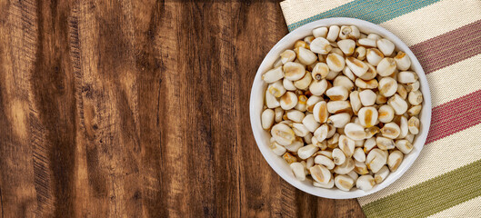 Top view of bowl with white corn for cooking on wooden table background