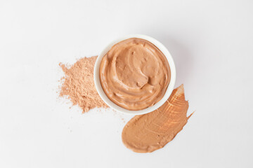 Bowl with cosmetic clay on white background