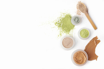 Jars with cosmetic clay on white background
