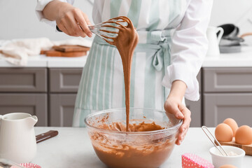 Woman preparing pastry in kitchen
