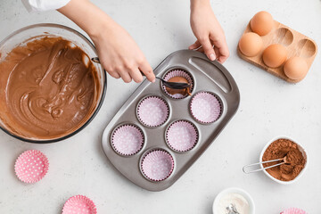Woman cooking cupcakes in kitchen