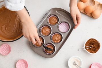 Woman cooking cupcakes in kitchen