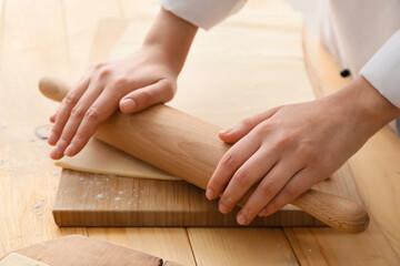 Woman making dough in kitchen