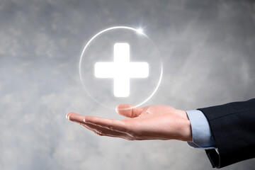 Businessman hold virtual plus medical network connection icons. Covid-19 pandemic develop people awareness and spread attention on their healthcare.