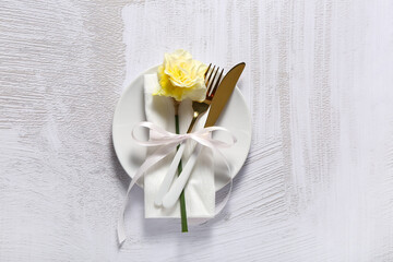 Fototapeta na wymiar Beautiful table setting with narcissus flower on light background