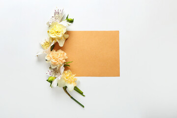 Beautiful flowers and blank card on light background
