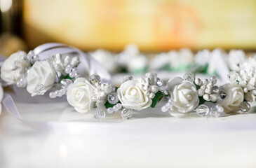 white festive wreath with artificial flowers on a light background