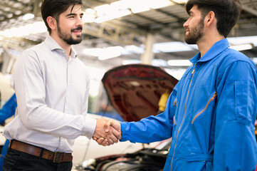 Obraz premium Car service, vehicle repair concept : Vehicle owner customer shaking hand with car service technician after sending his car for repairing or check at automobile service center.