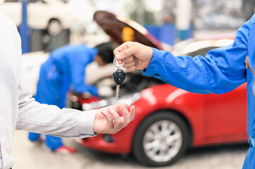 Car service, vehicle repair concept : Vehicle owner customer receiving car key from car service...