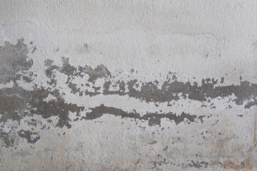 Old white concrete wall background with peeled off color surface.Caused by moisture.