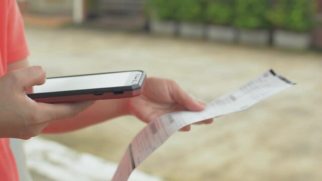 Woman scans QR Code. Payment of utility using Bar code with mobile device for electricity bill. Scanning and paying with smartphone.