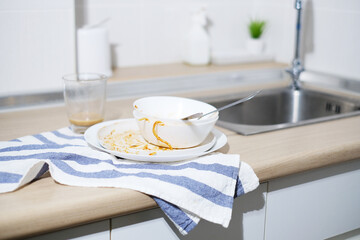 Piles of dirty dishes, bolws, cup, glasses in modern kitchen. Food container waiting for wash.