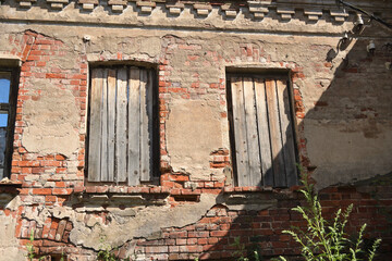 The wall of a ruined brick house.