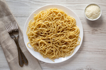 Homemade Cacio E Pepe Pasta with Pecorino Romano and Pepper on a white plate, top view. From above, overhead, flat lay.