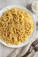 Homemade Cacio E Pepe Pasta with Pecorino Romano and Pepper on a white plate, top view. From above, overhead, flat lay. Close-up.