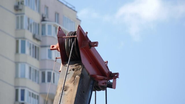 Tower Crane Hoist Rope against the blue sky and new building. Hawser of crane winch. Hoist Rope of Building crane. Crane lifting cables. Close Up.