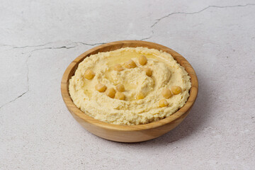 chickpea hummus on gray background. Bowl of tasty fresh hummus