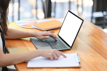 Cropped shot of businesswoman analyzing business data and while working with laptop computer in office.