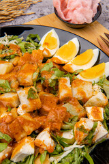 Gado Gado is an Indonesian salad of slightly boiled, blanched or steamed vegetables and hard-boiled eggs, boiled potato, fried tofu and tempeh, and lontong, served with a peanut sauce dressing.