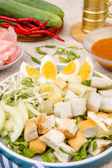 Gado Gado is an Indonesian salad of slightly boiled, blanched or steamed vegetables and hard-boiled eggs, boiled potato, fried tofu and tempeh, and lontong, served with a peanut sauce dressing.