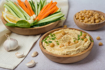 chickpea hummus with vegetables on gray background