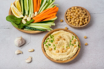 chickpea hummus with vegetables on gray background