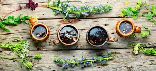 Mugs of herbal tea with various herbs