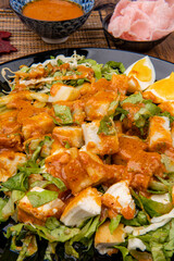Gado Gado is an Indonesian salad of slightly boiled, blanched or steamed vegetables and hard-boiled eggs, boiled potato, fried tofu and tempeh, and lontong, served with a peanut sauce dressing.