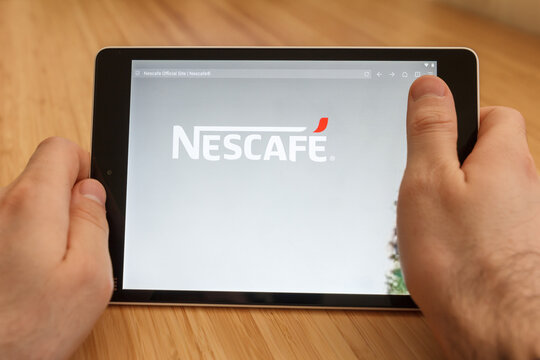 SAN FRANCISCO, US - 1 April 2019: Close up to hands holding tablet using internet and looking through Nescafe web site, in San Francisco, California, USA. An illustrative editorial image.