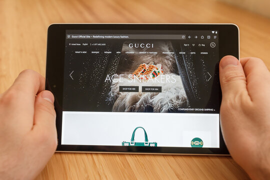 SAN FRANCISCO, US - 1 April 2019: Close up to hands holding tablet using internet and looking through Gucci web site, in San Francisco, California, USA. An illustrative editorial image.