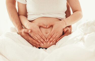 Fototapeta na wymiar Anonymous couple expecting baby touching belly