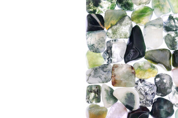 Moss agate heap jewel stones texture on half white light isolated background. Place for text.
