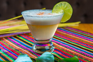 Traditional Peruvian pisco sour cocktail with a slice of lime - obrazy, fototapety, plakaty