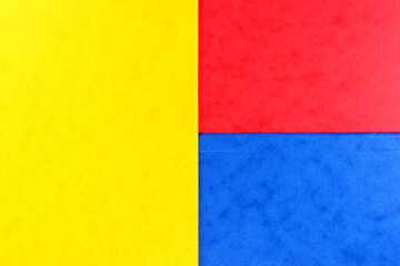 Blue, red and yellow color geometric paper composition background, top view