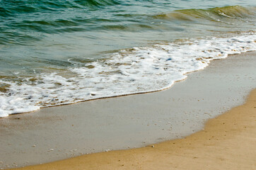 The lapping of the waves on the sandy beach.Small sea waves with crystal clear water on the sandy beach.
