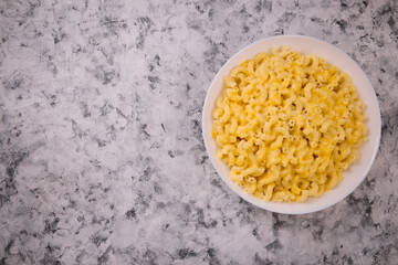 Macaroni and cheese on a white plate on a gray background
