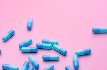 Blue capsule pills on pink background. Online pharmacy banner. Group of capsule pills. Pharmaceutical industry. Drug development and new drug research for treatment emerging Infectious diseases.