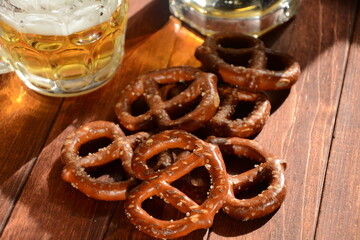 Hard Pretzels or Salted pretzels snack for party on rustic wooden table with glass of beer