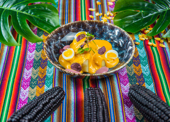 Papa a la Huancaina Peruvian boiled potatoes in hot sauce on a colorful peruvian traditional tablecloth