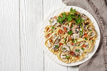 Spaghetti with mushrooms on a plate, copy space