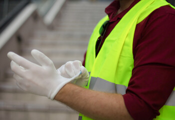 Fototapeta na wymiar Worker puts white gloves on his hand.